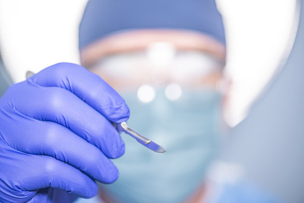 外科医生手持手术刀的特写图片下载