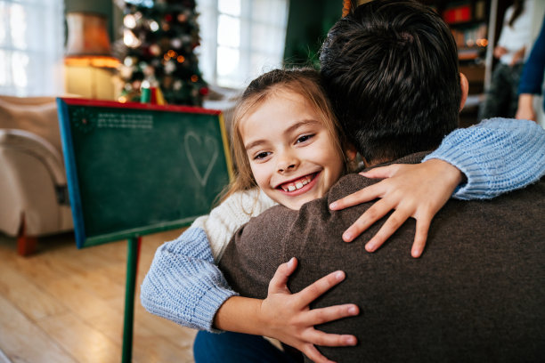 祝全家快乐，父亲节快乐。父亲和他的女儿拥抱在一起，玩得很开心图片下载