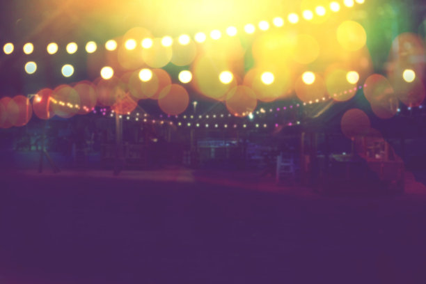 模糊的散景灯与黄色串灯装饰在海滩餐厅在黄昏的夏季背景图片下载