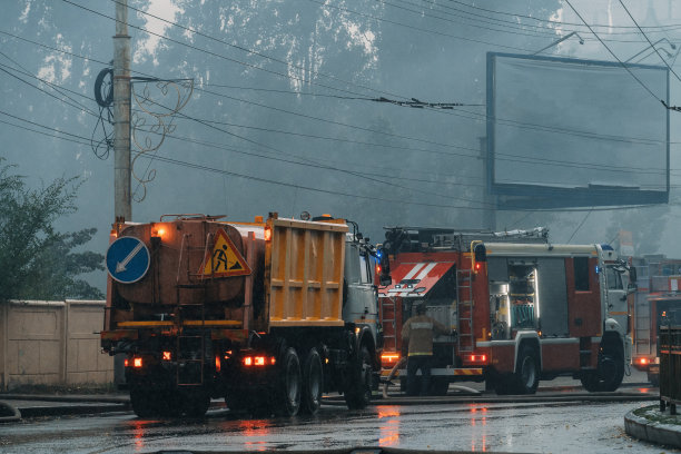 消防车已到达火灾现场。下雨的时候，街道上的火冒烟。事故和灾害图片下载