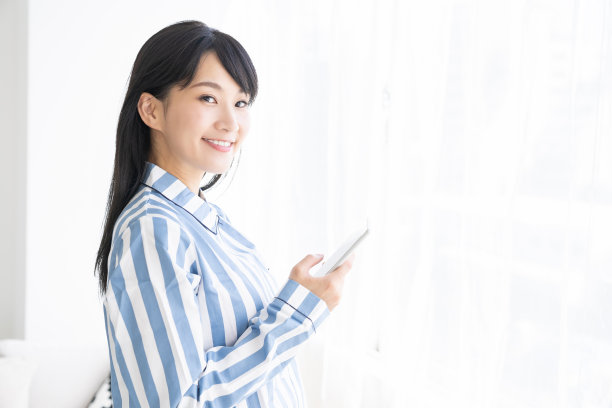 穿着睡衣的亚洲女人，还有智能手机图片下载