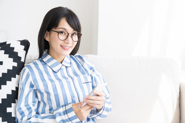 穿着睡衣的亚洲女人，还有智能手机图片下载