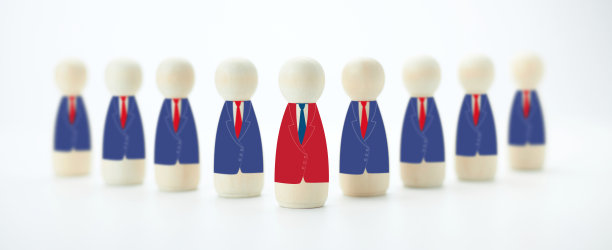 穿着西装的木制玩偶站成一组的照片。图片下载