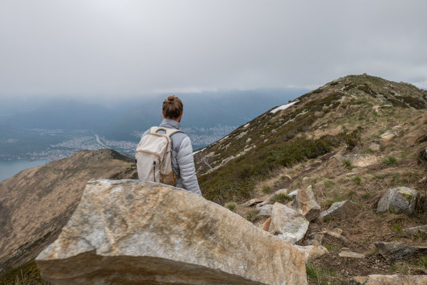 年轻男人在山脊上徒步旅行，阴天图片下载
