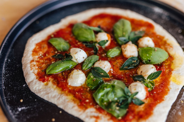 一张在火上烤的披萨的照片。图片下载