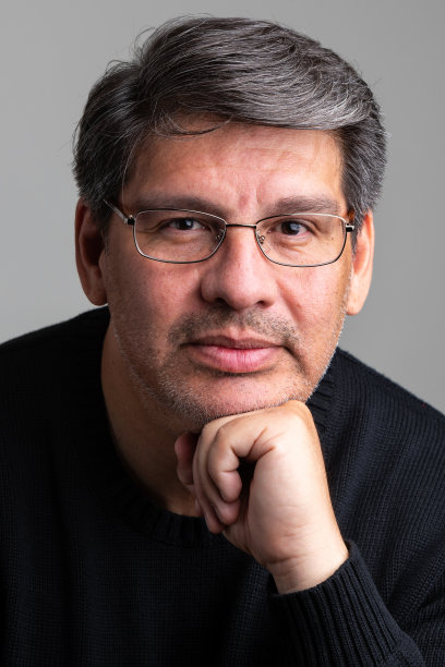 沉思的成熟男子看着灰色背景上的相机图片下载