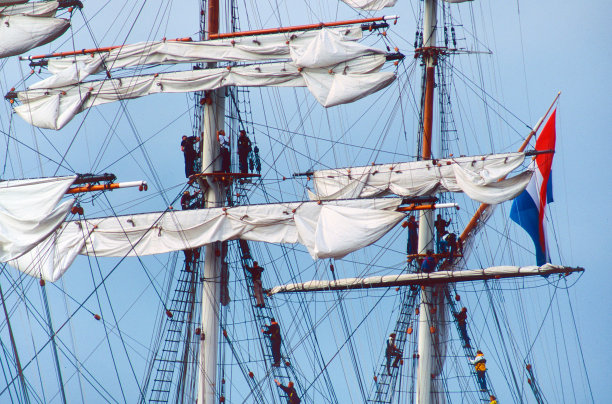 水手们正在爬一艘历史悠久的老帆船上的绳梯图片下载