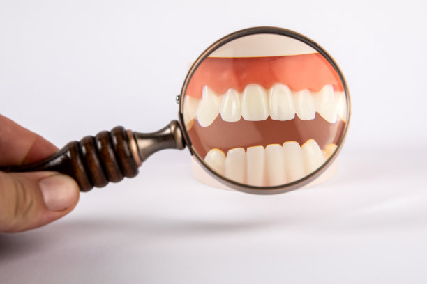用放大镜在白色背景上进行牙科研究图片下载