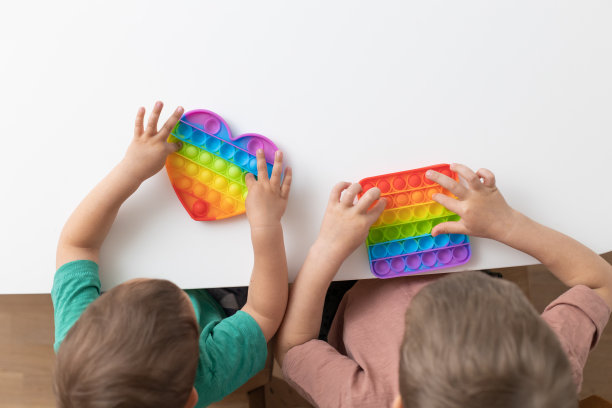 可爱的孩子们玩着Pop It坐立不安。新抗压力游戏-推爆泡泡柔韧坐立不安。感官玩具用于放电，发育儿童图片下载