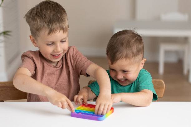 可爱的孩子们玩着Pop It坐立不安。新抗压力游戏-推爆泡泡柔韧坐立不安。感官玩具用于放电，发育儿童图片下载