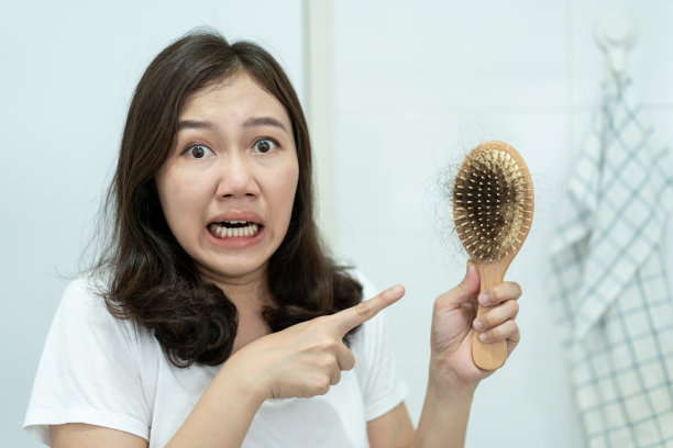 关注头发掉落问题的亚洲年轻女性。图片下载