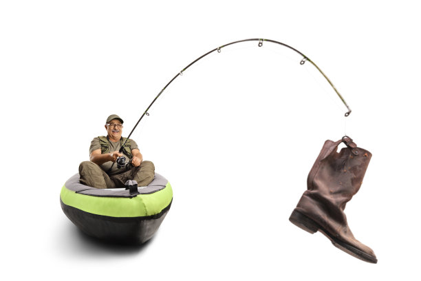 独木舟上的渔民，鱼钩上挂着旧靴子图片下载