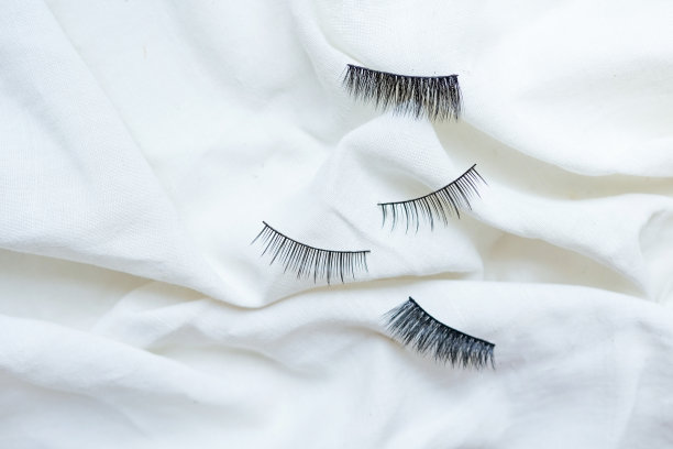 棉白色背景上的黑色假睫毛图片下载