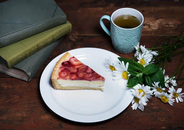 盘子上的草莓芝士蛋糕特写。照片采用乡村风格。舒适和居家氛围的概念。社交网络和烹饪博客的照片。家庭糖果的广告。图片下载