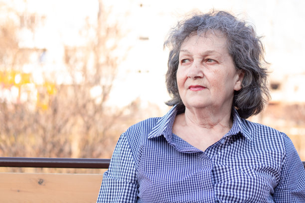 在欧洲城市景观的背景下，一个老年妇女的街道肖像，中等平面。图片下载