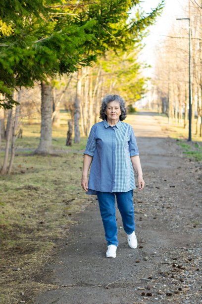 一位老妇人夏天在公园里散步图片下载