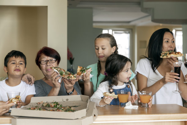 一个快乐幸福的家庭在家庭厨房里享受披萨时光。图片下载