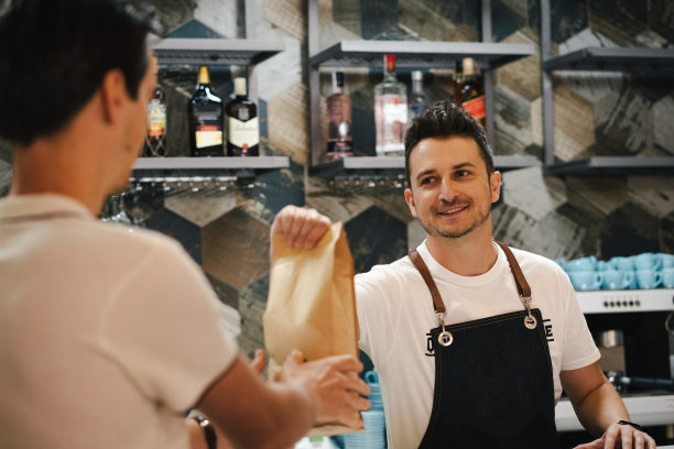 积极的企业主站在后面的酒吧在咖啡店图片下载