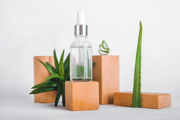 用移液管吸液于木块裙板和芦荟上。天然材料制成的护肤化妆品。前视图。图片下载