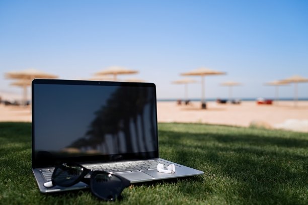 笔记本电脑背景热带海滩。远程工作，暑假概念，在海滩上工作，自由职业和假期图片下载