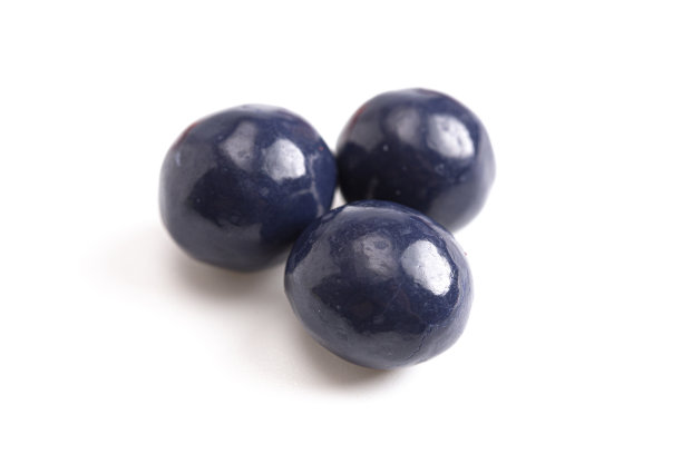 蓝色涂层巧克力覆盖干蓝莓在白色的背景图片下载