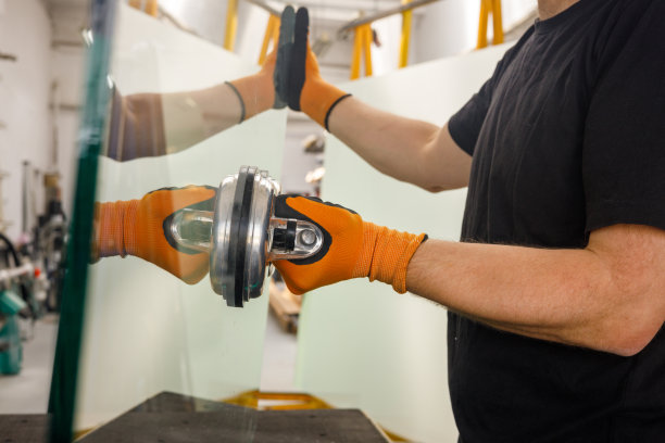 玻璃工用吸盘拿着一块厚玻璃，玻璃工厂，专业工作工具图片下载