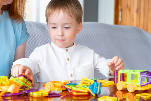 白人男孩玩磁力构造器玩得很开心。有选择性的重点。在幼儿园和家里的早期发育图片下载