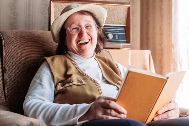 戴着帽子的老妇人，在窗边看书。午后的阳光图片下载