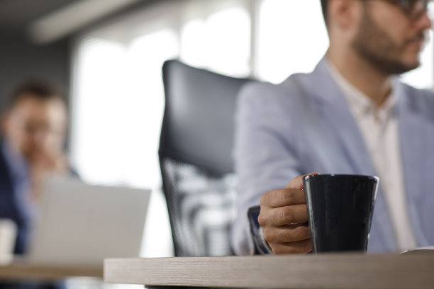 他边喝咖啡边伏案工作图片下载