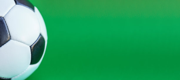 运动、足球、竞赛、体育文化、健康生活方式概念-旗帜特写黑白经典足球皮球在一个纯绿色背景色makey复制空间图片下载