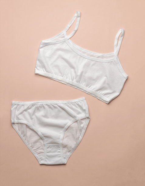 一套时尚的经典女性内衣在米色背景。平的。图片下载