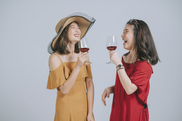 时尚的亚洲华人夏装拿着酒杯工作室拍摄剪出灰色的背景图片下载