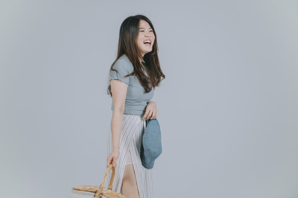 美丽的亚洲中国女人与夏天穿着携带野餐篮子微笑工作室拍摄剪出与灰色背景图片下载