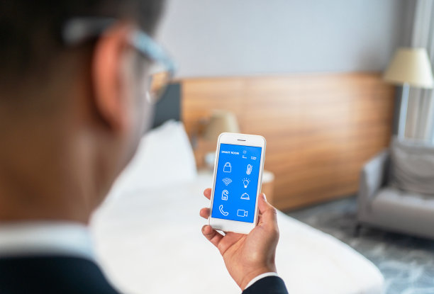 商人在智能手机屏幕上使用智能房间应用程序İn酒店房间图片下载