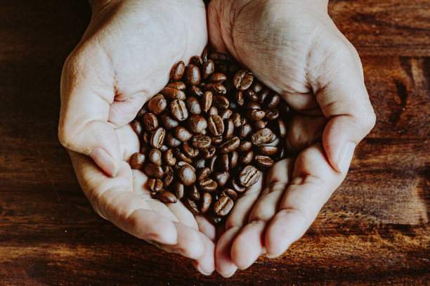 咖啡豆在木桌上呈心形造型图片下载