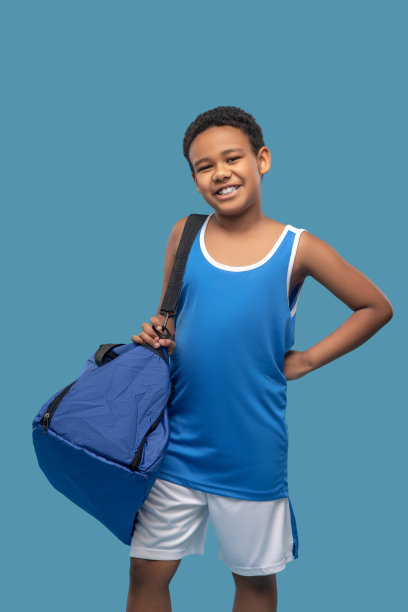 快乐的黑皮肤男孩和运动包图片下载
