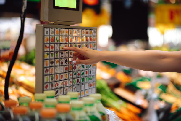 女人的手在超市蔬菜部的电子秤上选择自己想要的位置。贸易组织。方便和自助服务。图片下载