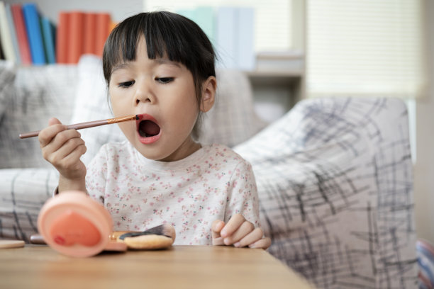 小女孩在玩妈妈的化妆品和镜子图片下载