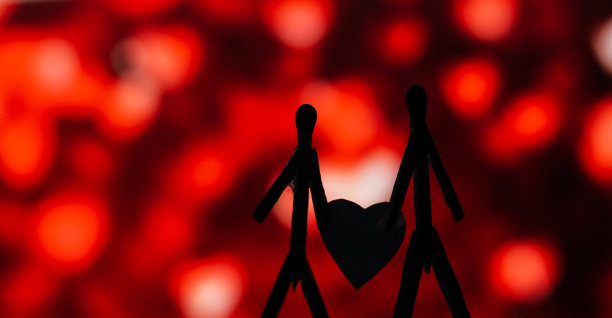 爱的夫妻用火柴棍的概念。男性和女性靠在一起，背景是美丽的心形。火柴艺术摄影用火柴棒创造了这个人物。图片下载