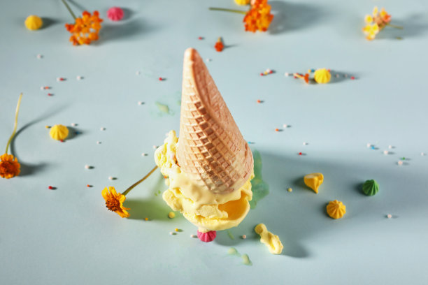 蓝色背景上的华夫饼筒香蕉冰淇淋和黄色花朵图片下载