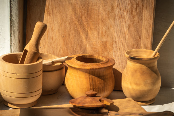 一个乡村房子的窗台上的家的乡村木制餐具被早晨的太阳照亮，特写图片下载