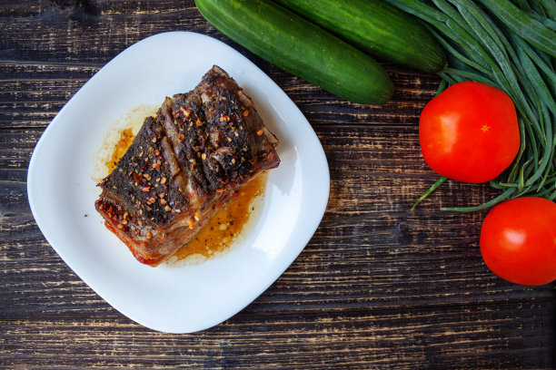 麻辣炸猪肉，新鲜的红番茄，黄瓜和葱羽毛在一个木制的背景-工艺食品图片下载