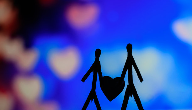 爱的夫妻用火柴棍的概念。男性和女性靠在一起，背景是美丽的心形。火柴艺术摄影用火柴棒创造了这个人物。图片下载