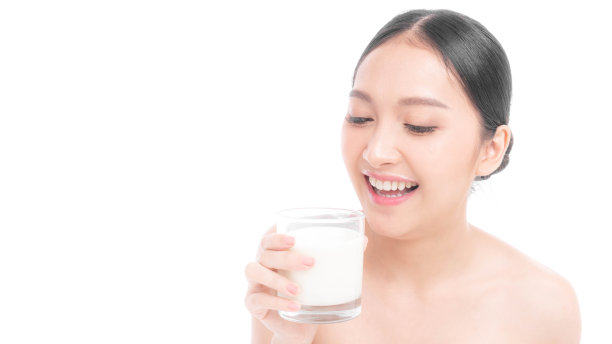 在白色的背景下，亚洲可爱的女孩在早晨喝牛奶以保持健康时感到快乐——生活方式的美丽女人概念图片下载