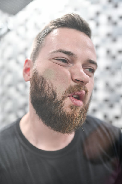 有趣的男性把脸贴在镜子里图片下载