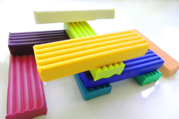 一块块橡皮泥按照彩虹的颜色排列整齐，白色的背景图片下载