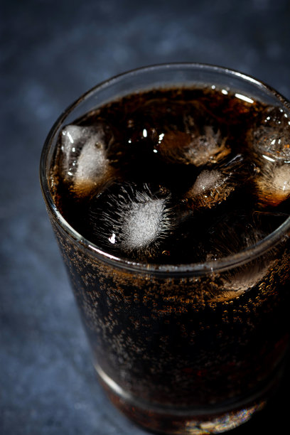 一杯可口可乐与冰在一个黑暗的背景，俯视图垂直图片下载