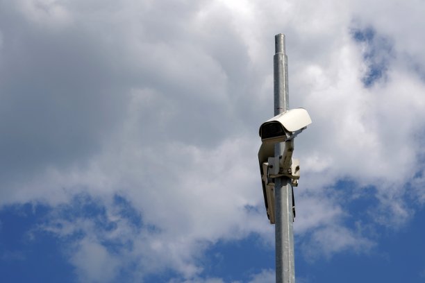 闭路电视摄像机安装在一根金属杆上，背景是天空，有很多拷贝空间。它为私人和公司的财产保护服务。图片下载