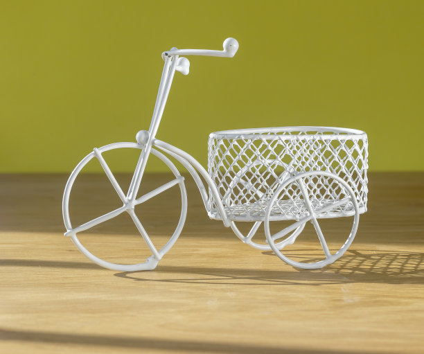 可爱的复古自行车玩具和篮子在木制的桌子上，越过黄色的墙。夏天共鸣图片下载