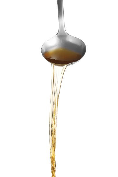 用勺子将面汤浇在白色的背景上，汤用于鸡和鱼的素喜烧图片下载